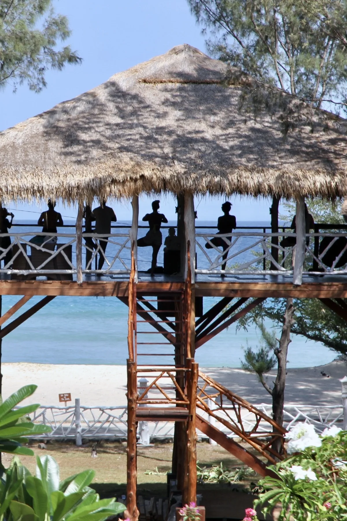 Yoga silhouettes in the ocean-view pavilion
