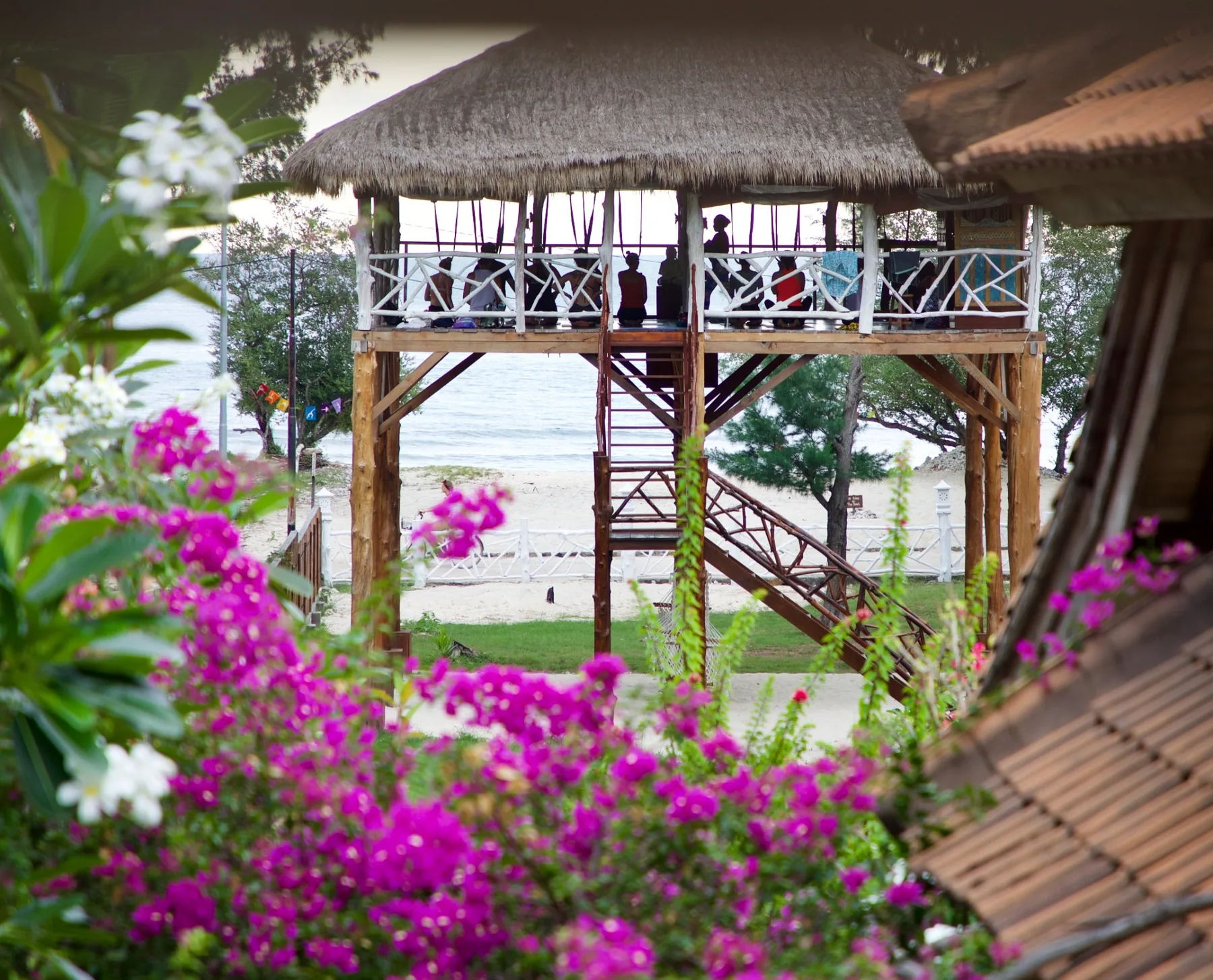 Ocean-view yoga pavilion framed by flowers at Sunset Beach Yoga